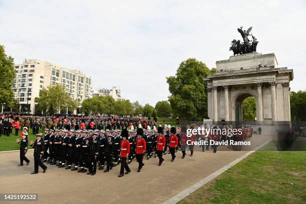 The coffin of Queen Elizabeth II with the Imperial State Crown resting on top, borne on the State Gun Carriage of the Royal Navy followed by members...