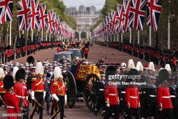 The Queen's funeral cortege borne on the State Gun Carriage of the Royal Navy travels along The Mall with the Gentlemen at Arms on September 19, 2022...