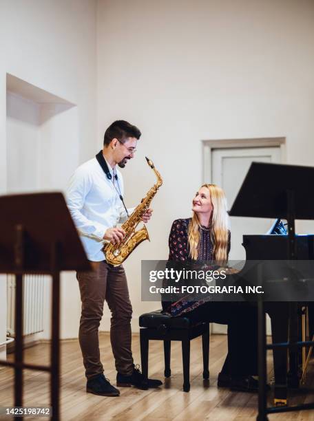 duet with piano and saxophone practising together - duet stock pictures, royalty-free photos & images