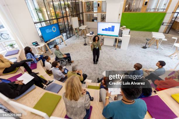 african woman addressing audience at startup launch event - differing abilities female business fotografías e imágenes de stock