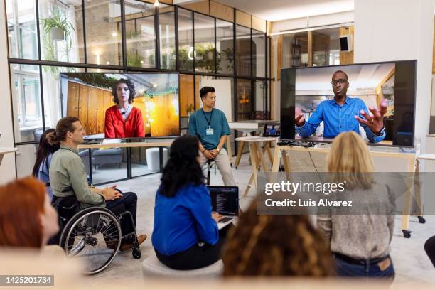 businessman connecting via video call with entrepreneurs during startup conference - differing abilities female business fotografías e imágenes de stock