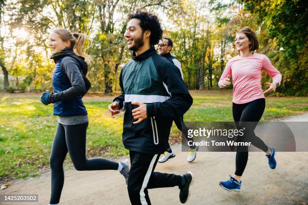 happy and  joggers - laufen und gras und sport stock-fotos und bilder