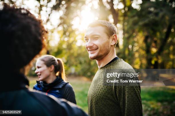 sports friends chat and laugh during their workout session in the park - conversion sport stock pictures, royalty-free photos & images