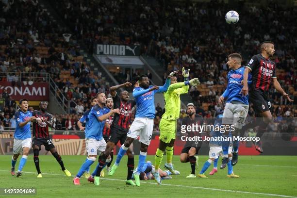Mike Maignan of AC Milan attempts to make contact with a corner kick as he leaps with Andre Anguissa of SSC Napoli as the host attack their opponents...