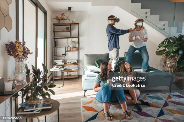 four friends playing or watching a movie with virtual reality headset - game four stockfoto's en -beelden