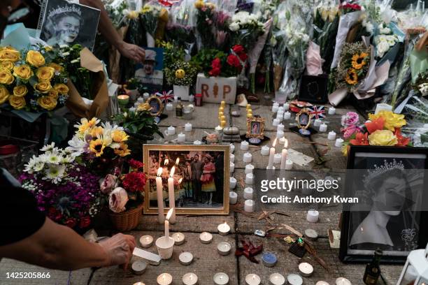 Mourners place candles next to flower tributes for Queen Elizabeth II outside the British Consulate as the world reacts to the passing Of Queen...