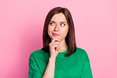 Photo portrait of nice young lady skeptical look empty space not believe doubt dressed trendy green look isolated on pink color background
