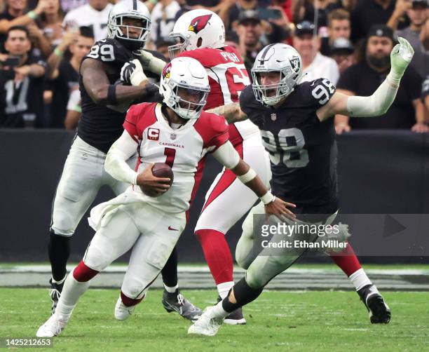Quarterback Kyler Murray of the Arizona Cardinals avoids a tackle by defensive end Maxx Crosby of the Las Vegas Raiders in the fourth quarter of...