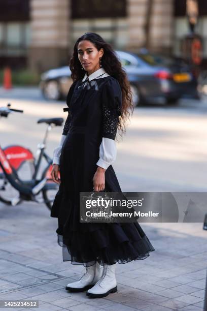 Ciinderella Balthazar is seen wearing a white blouse, black ruffled tulle long dress, black embroidered box bag and white leather boots, outside Mark...