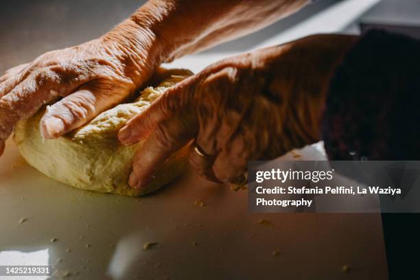 senior woman's hands kneading dough - dough photo stock-fotos und bilder