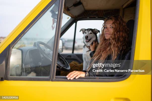 hippie woman with a dog inside an old van - husky fotografías e imágenes de stock