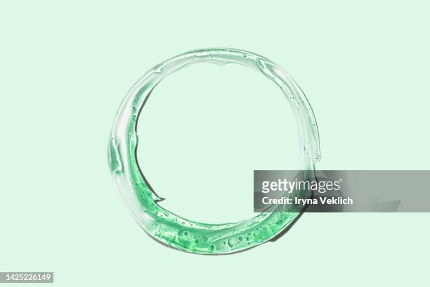 green color smear of gel,  face serum or essential oil, shampoo, soap with oxygen aqua bubbles on green color background. - duschgel nobody stock-fotos und bilder