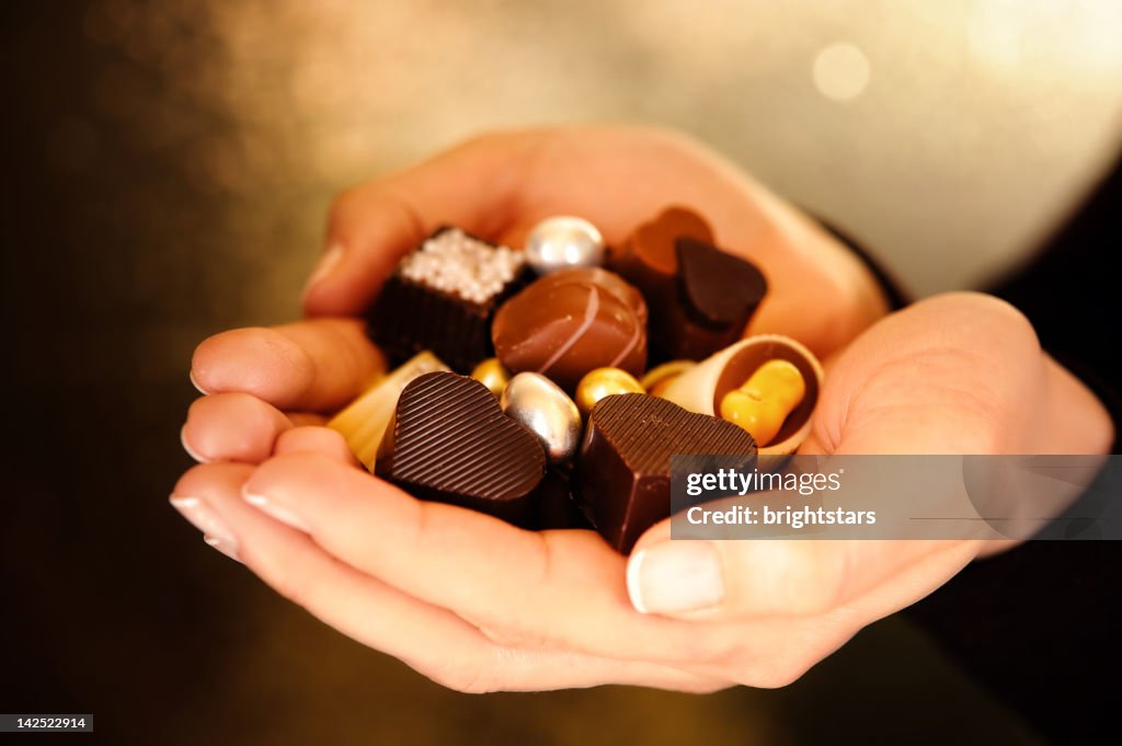 Young woman holding chocolates in hand