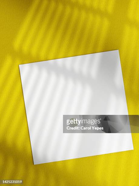 paper blank,template.in yellow surfacee casting shadows - counter surface level stock pictures, royalty-free photos & images