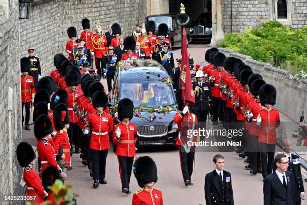 The coffin of Queen Elizabeth II is carried in The state hearse as it proceeds towards St. George's Chapel followed by Prince Edward, Earl of Wessex,...