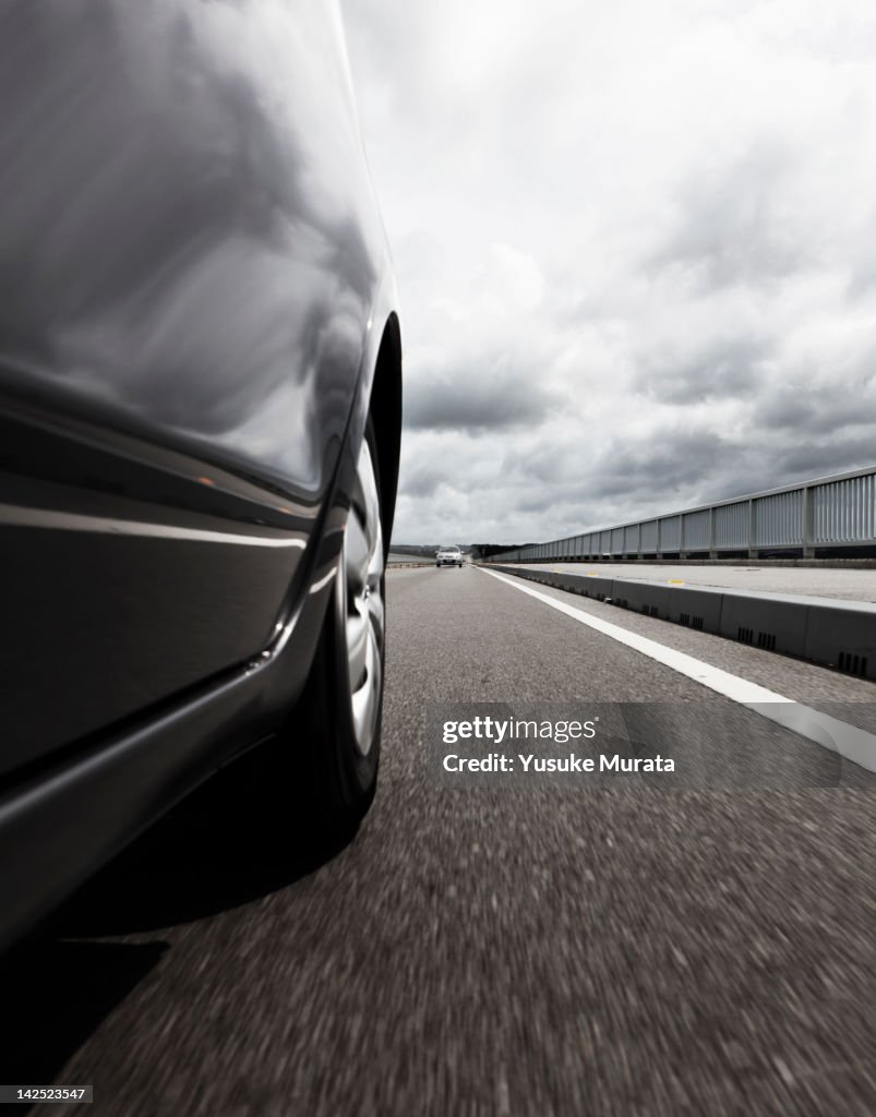 Behind view of car driving along coastal road