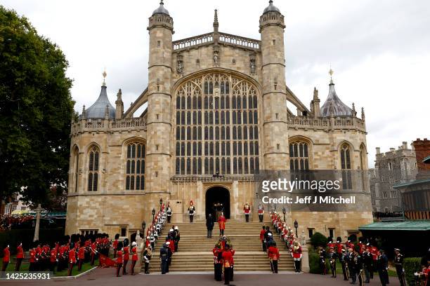 Pall bearers from the Queen's Company, 1st Battalion Grenadier Guards carry the coffin of Queen Elizabeth II with the Imperial State Crown resting on...