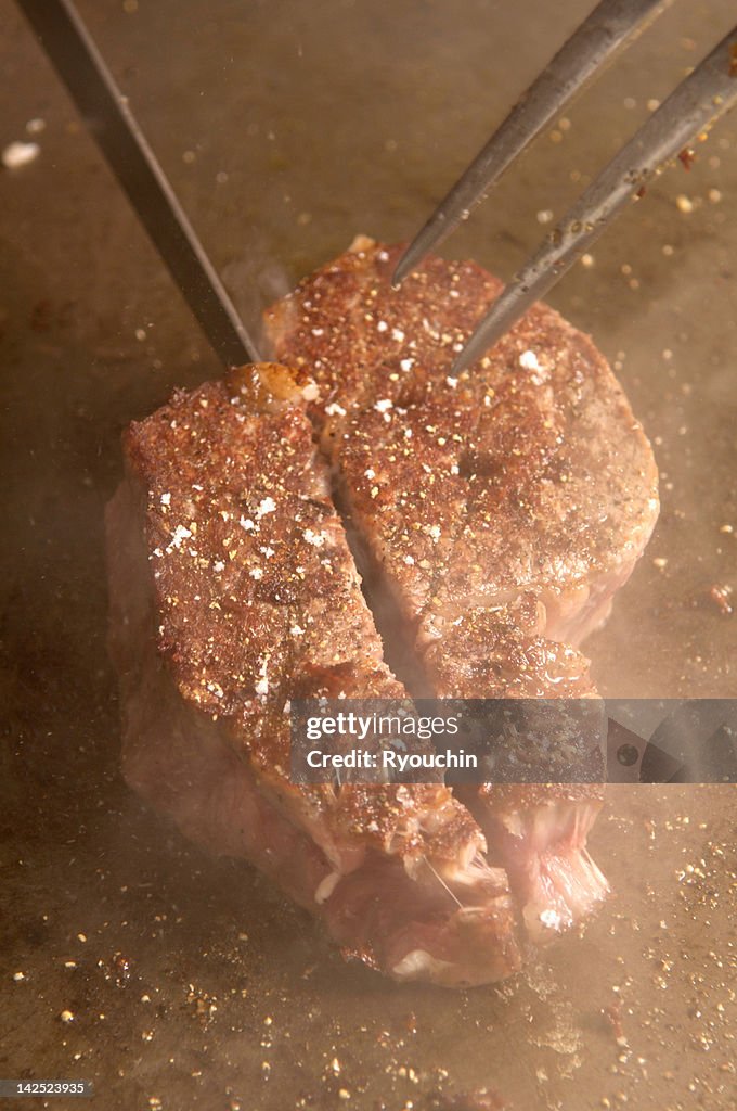 Food,beefsteak?meat roasted on a hot plate