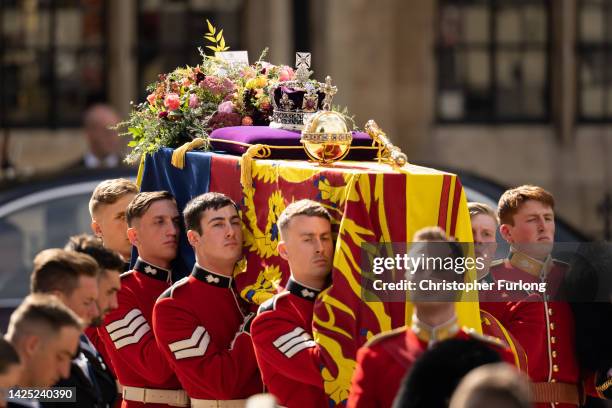 The coffin of Queen Elizabeth II with the Imperial State Crown resting on top is carried by the Bearer Party as it departs Westminster Abbey during...
