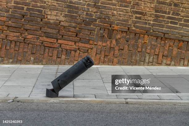 broken bollard on sloping street - bollard stock-fotos und bilder