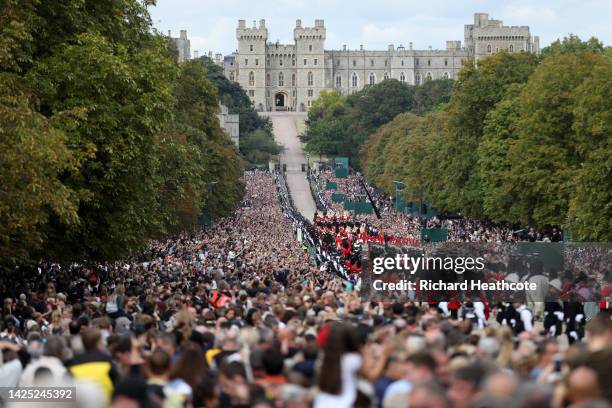 Mourners watch the State Hearse of Queen Elizabeth II as it drives along the Long Walk ahead of the Committal Service for Queen Elizabeth II on...