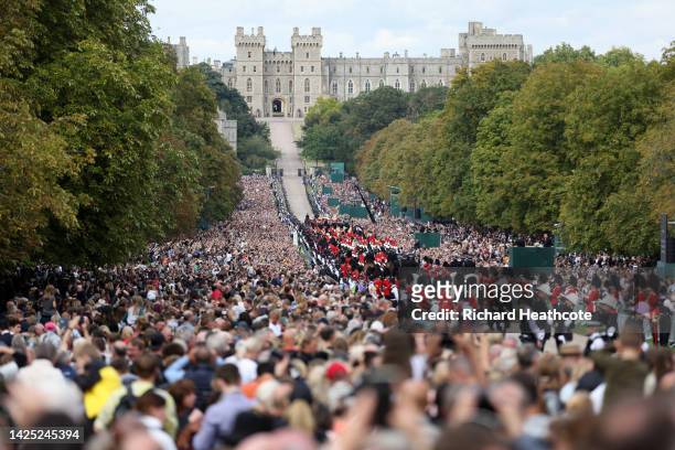 Mourners watch the State Hearse of Queen Elizabeth II as it drives along the Long Walk ahead of the Committal Service for Queen Elizabeth II on...