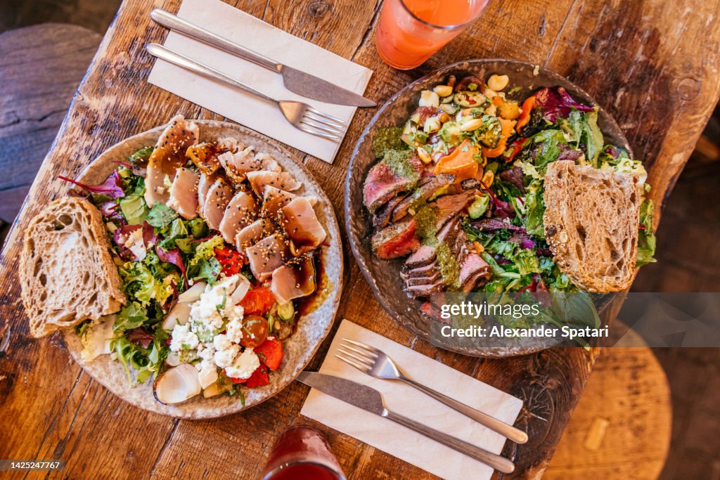 Healthy lunch with tuna, beef steak and salads, high angle view