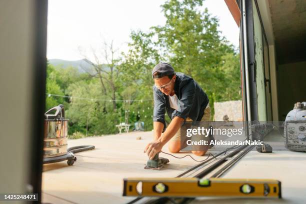 carpenter sanding wooden decking - sander stock pictures, royalty-free photos & images
