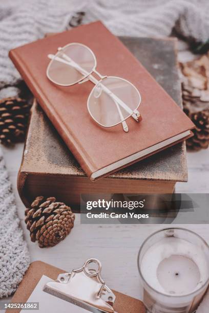 vintage book, feathers,eyeglasses, candle cozy blogger concept - winter plumage stock pictures, royalty-free photos & images