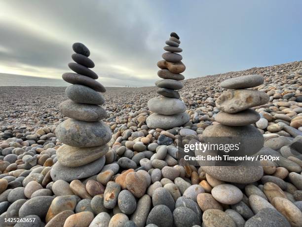 close-up of stacked stones against sky - balance stones stock pictures, royalty-free photos & images
