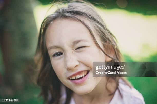 closeup portrait of smiling girl blinking - blinking stock pictures, royalty-free photos & images