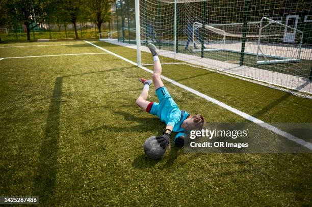 teenage girl goalkeeper making a save during soccer training - redding sporten stockfoto's en -beelden