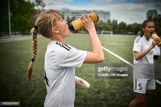 teenage girl drinking from bottle on soccer field - local soccer field stock pictures, royalty-free photos & images