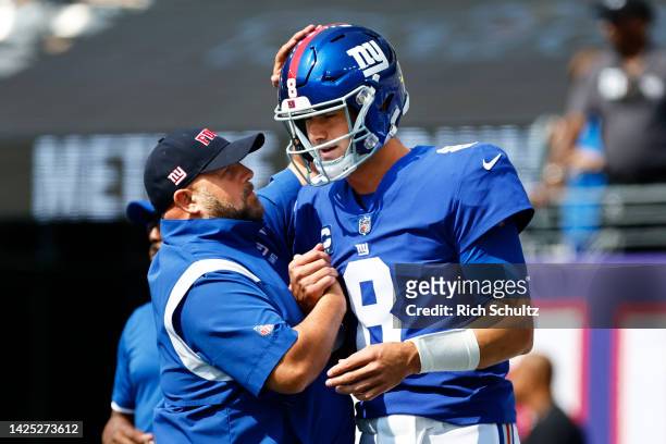 Head coach Brian Daboll of the New York Giants talks with quarterback Daniel Jones before a game against the Carolina Panthers at MetLife Stadium on...
