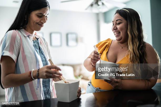 friends talking and eating asian food at home - chinese takeout stock pictures, royalty-free photos & images