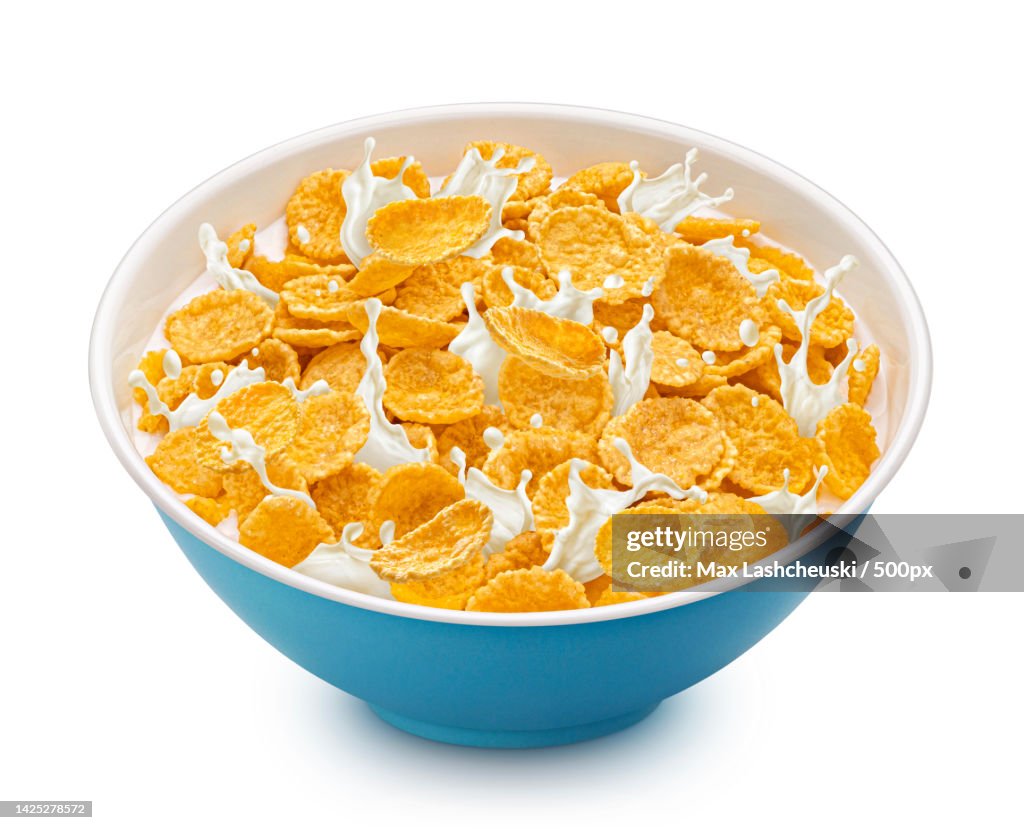 Corn flakes with milk splashes isolated on white background