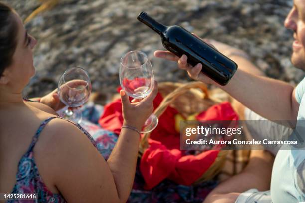 couple in love showing their love on a summer afternoon having a picnic in the field - dating show stock pictures, royalty-free photos & images