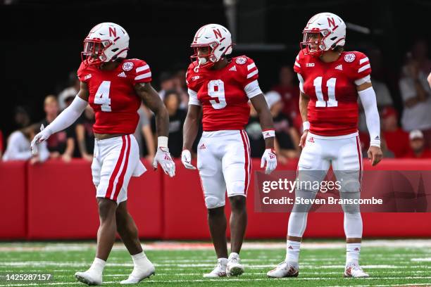 Wide receiver Alante Brown of the Nebraska Cornhuskers and running back Ajay Allen and quarterback Casey Thompson look to the sidelines before a play...