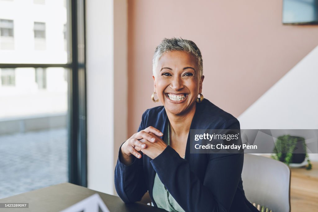 Senior, happy and smile of a proud corporate woman ceo of a company at her office desk. Portrait of a business leader, manager and boss feeling worker, career and management success at a company