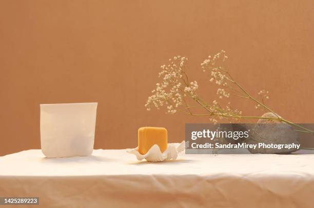 bars of soap on a yellow and white background, with marine and floral decoration, with a white paper packaging bag - flexible packaging stock pictures, royalty-free photos & images