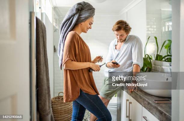 young couple getting ready in their bathroom at home - koppel toilet stockfoto's en -beelden