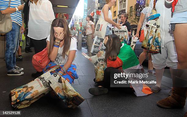 Young female fans are seen crying after purchasing merchandise at the One Direction promotional store opening on Pitt Street on April 7, 2012 in...