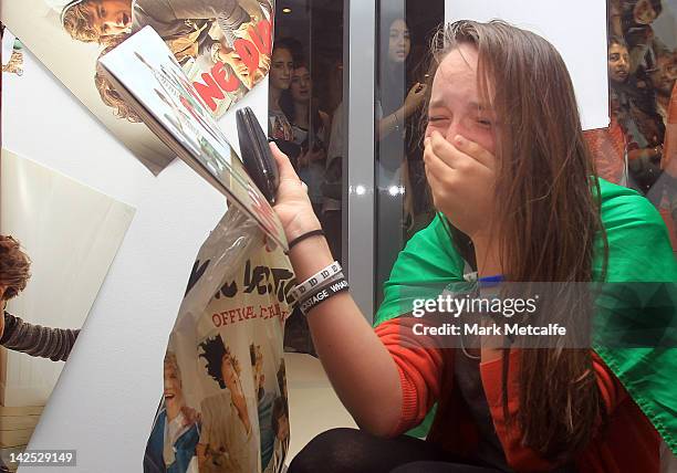 Young female fan is seen crying after purchasing merchandise at the One Direction promotional store opening on Pitt Street on April 7, 2012 in...