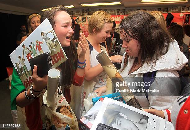 Young female fans are seen crying after purchasing merchandise at the One Direction promotional store opening on Pitt Street on April 7, 2012 in...