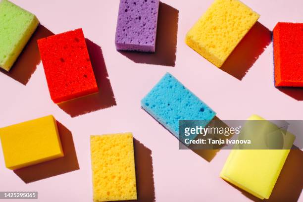 colored sponges for washing dishes and cleaning on pink background. the concept of cleanliness in the house - topfreiniger stock-fotos und bilder