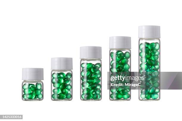 transparent glass bottles filled with soft gel capsules from small to large isolated on white - full transparency stock pictures, royalty-free photos & images