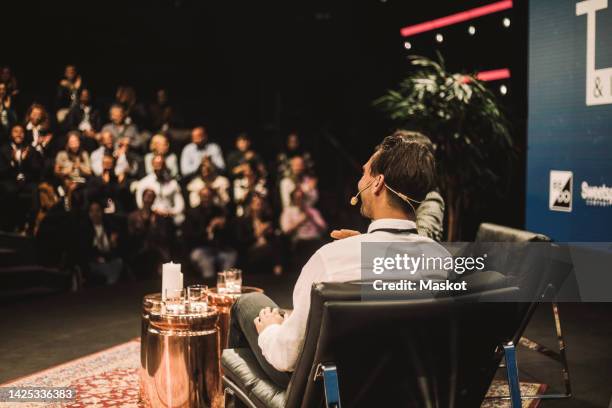 male tech entrepreneur with interviewer during conference event at convention center - conference event stage stock pictures, royalty-free photos & images