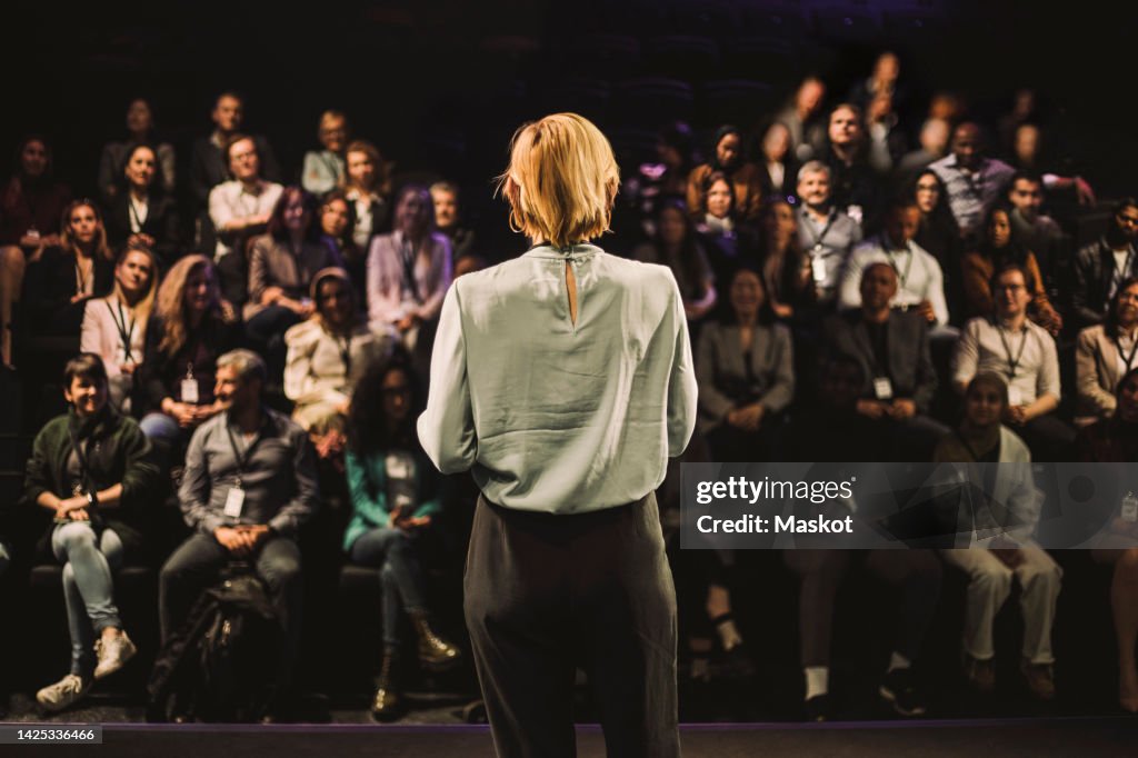 Mature tech entrepreneur interacting with audience in panel discussion at convention center