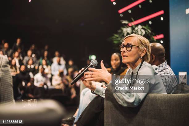 female tech entrepreneur talking with interviewer during panel discussion - tableau de commande photos et images de collection