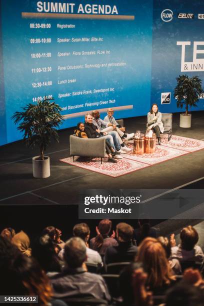 tech entrepreneurs interacting with audience during panel at convention center - women podium stock-fotos und bilder